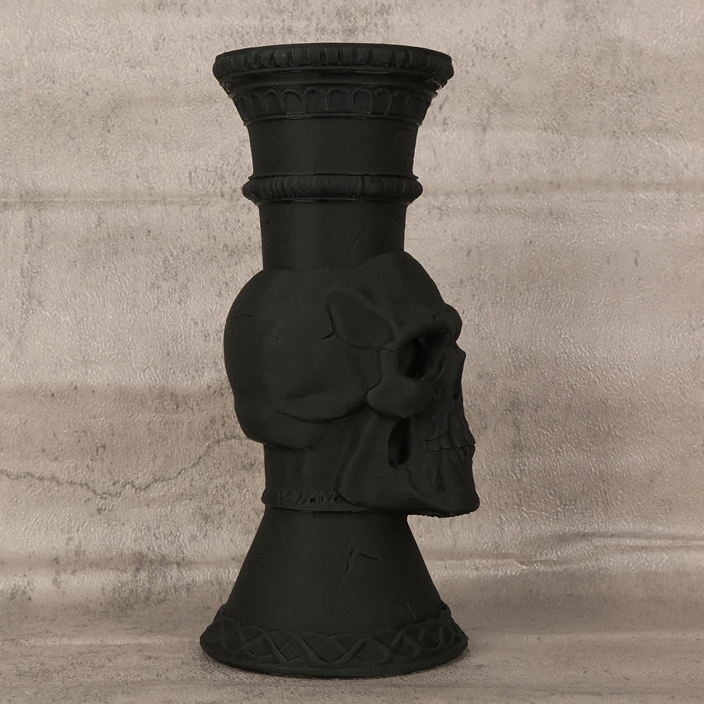 A black skull-shaped decorative vase with a ribbed neck and flared base.
