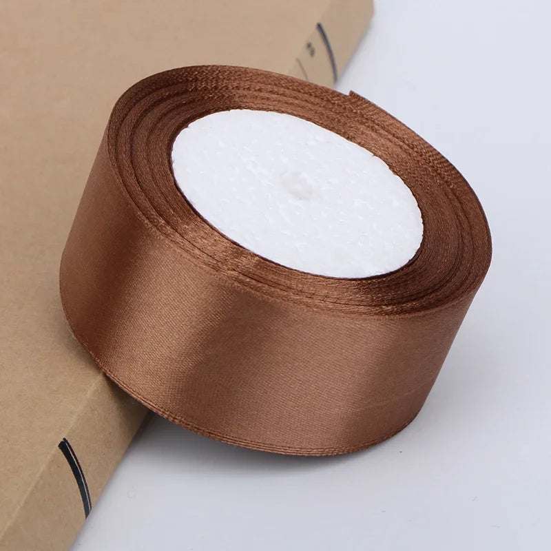 Roll of satin ribbon in a brown color with white batting for crafts and gift wrapping