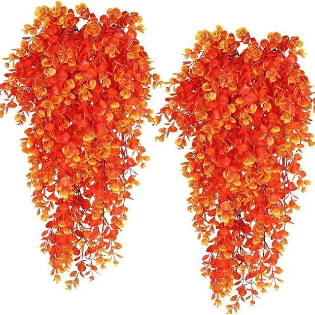 Two strands of artificial black vine hanging plants with bright orange and red leaves