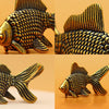 A close-up view of a retro brass goldfish statue with textured scales, shown from multiple angles.