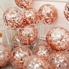 A collection of rose gold sequin balloons in various sizes displayed on a white shelf.