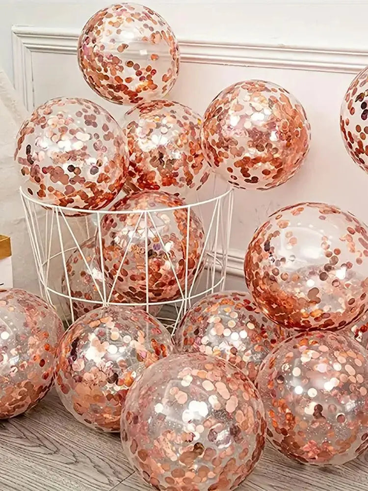 A collection of rose gold sequin balloons in various sizes displayed on a white shelf.