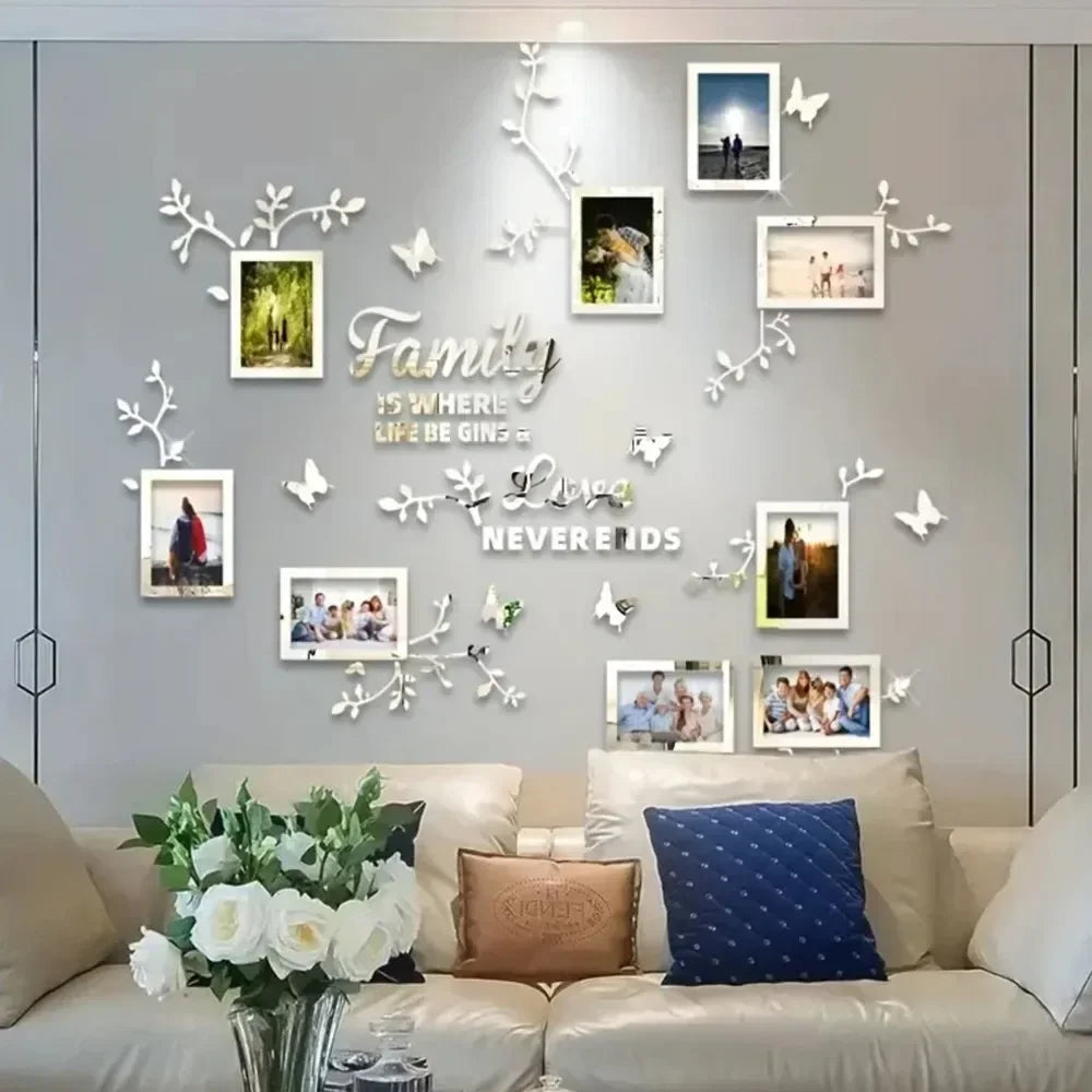 A gray wall decorated with white acrylic tree decals and framed photos, featuring a sofa and pillows.