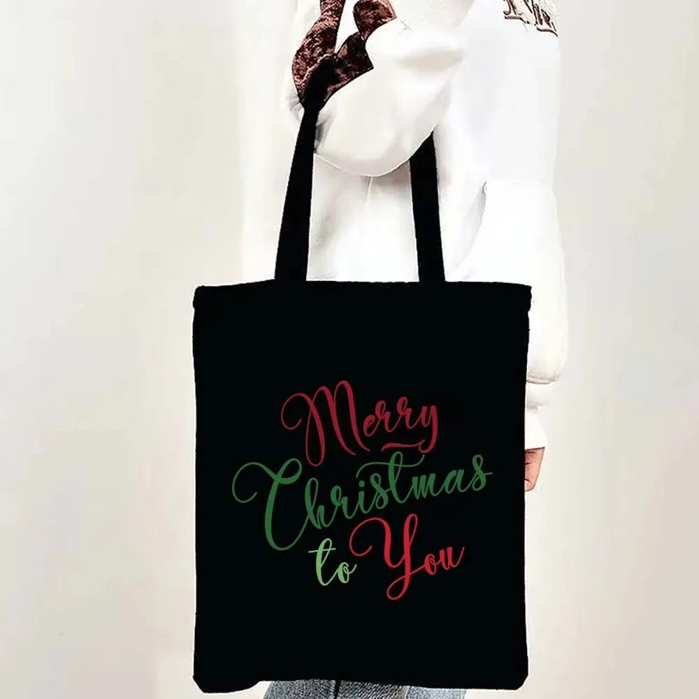Black tote bag with pink and green script text that reads Merry Christmas to you