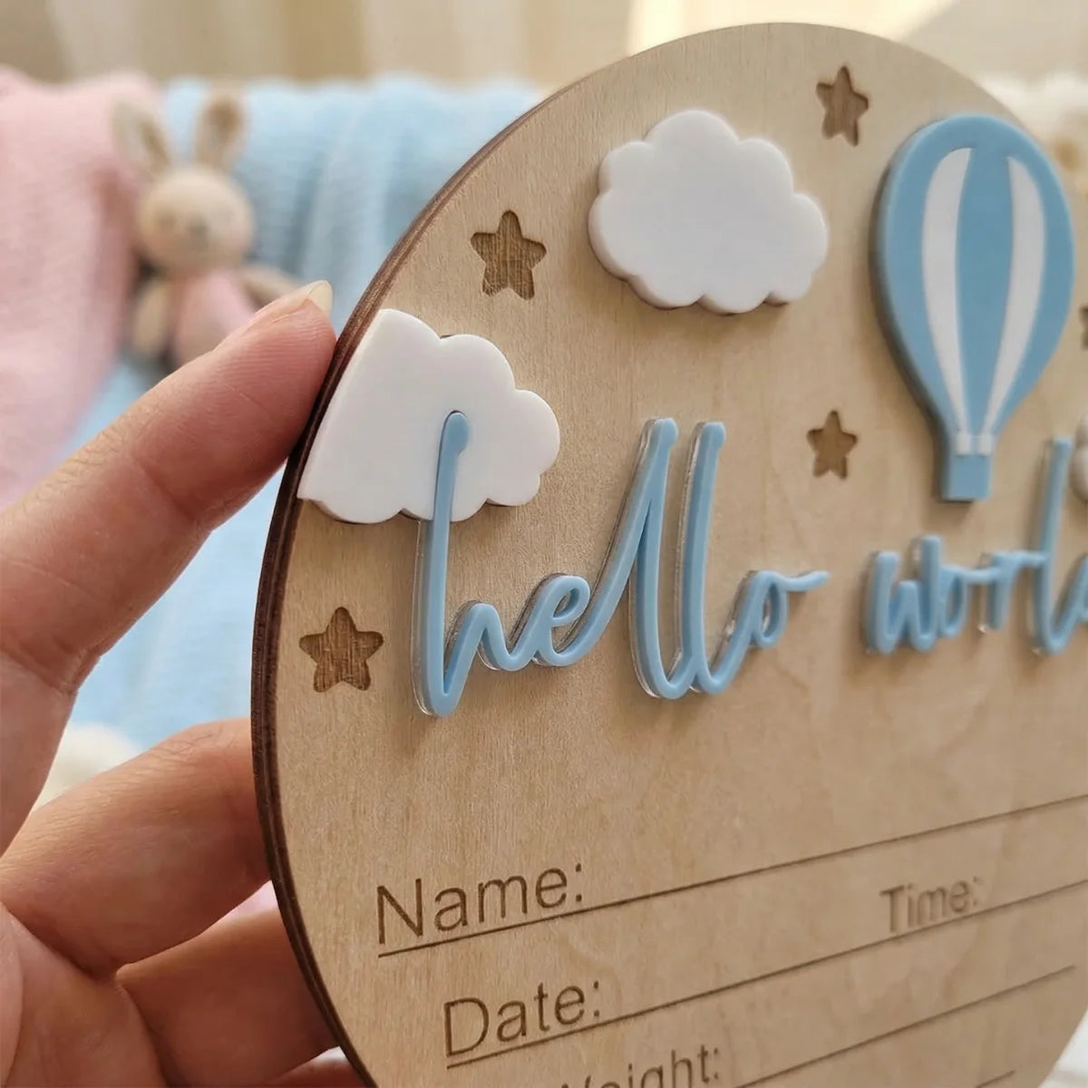 A wooden birth announcement plaque decorated with clouds, stars, and a hot air balloon, featuring a personalized name and dat