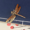 Vintage brass dragonfly desk decor featuring a detailed insect with translucent wings.