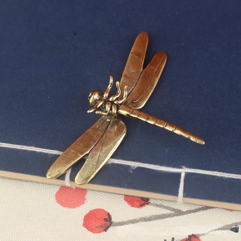 Vintage brass dragonfly desk decor featuring a detailed insect with translucent wings.