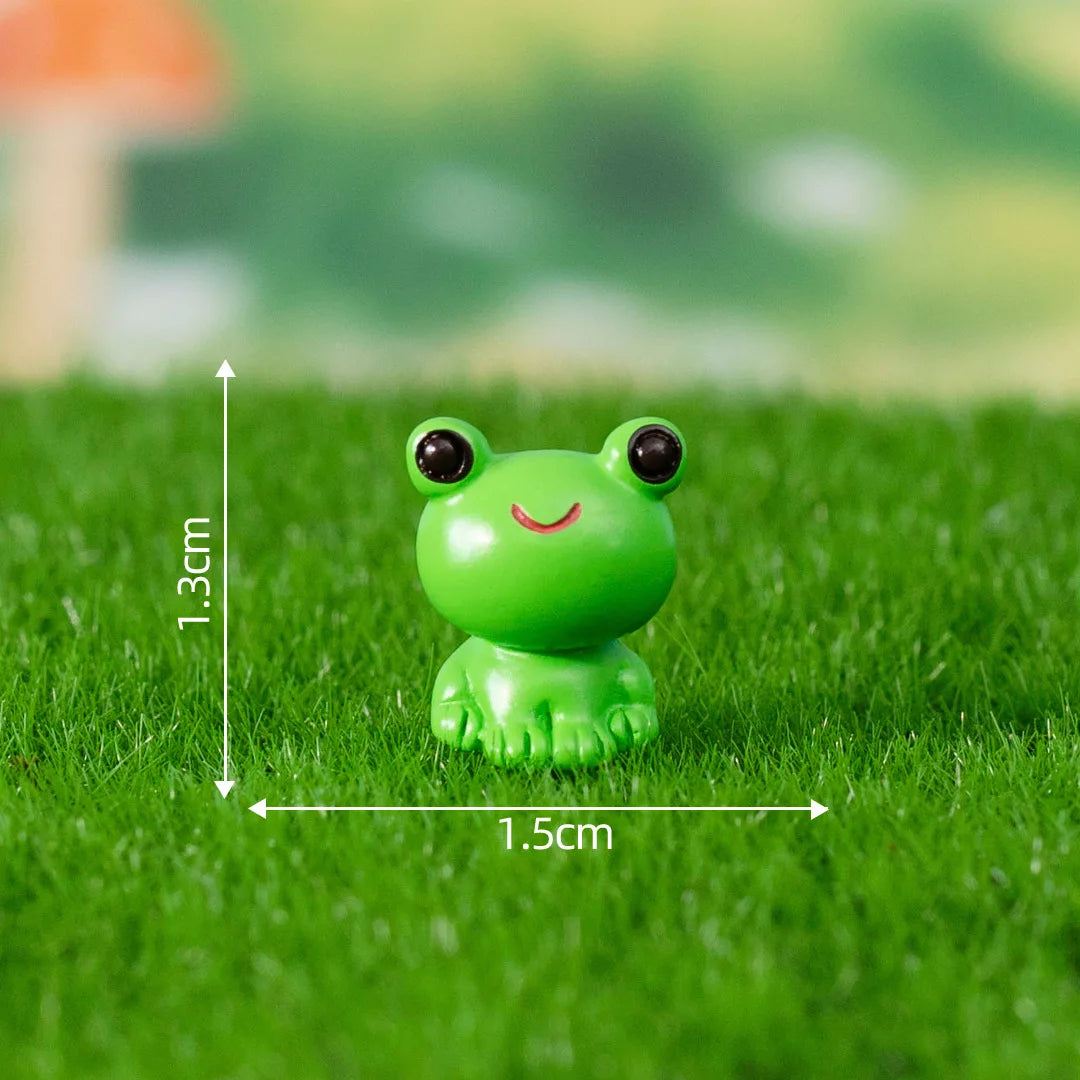 A small, bright green frog figurine is placed on green grass.