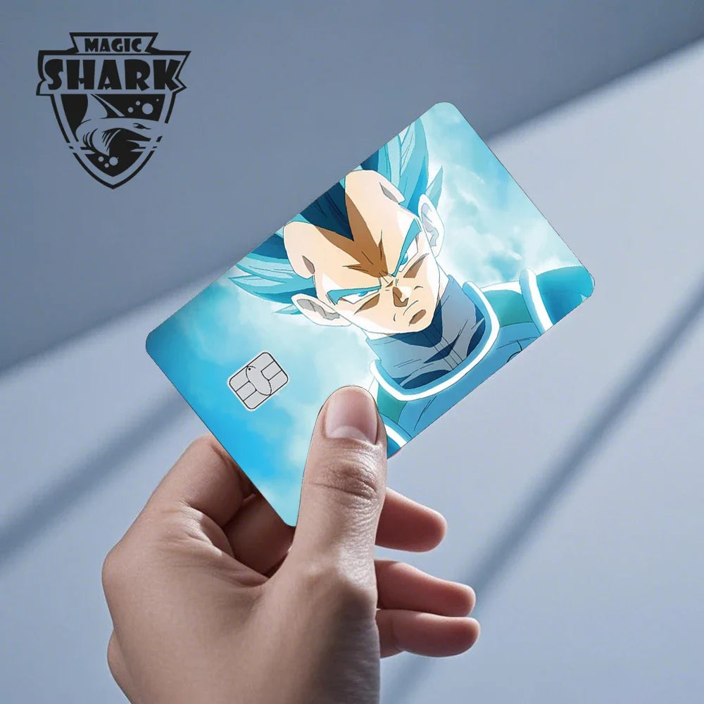 A hand holds a Dragon Ball Super Saiyan card skin sticker featuring Goku in a blue and white outfit against a light backgroun