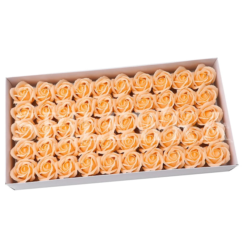A box filled with numerous artificial peach-colored rose heads for wedding and party decoration.