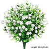 Un bouquet de fleurs blanches artificielles avec des feuilles vertes.