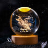 A spherical crystal ball decoration with a dark background and gold-colored light, featuring the constellation Taurus.