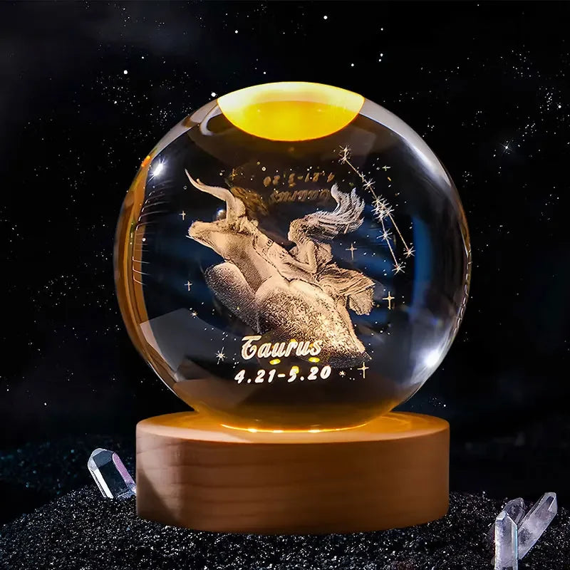 A spherical crystal ball decoration with a dark background and gold-colored light, featuring the constellation Taurus.
