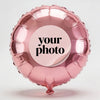 A pink foil balloon shaped like a heart, featuring a circular sticker with the text your photo.