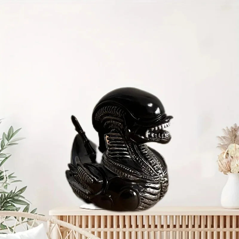 Black resin statue of an alien duck with textured skin sitting on a wooden surface.