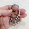 A hand holds a durable stainless steel keychain with multiple interlocking loops.