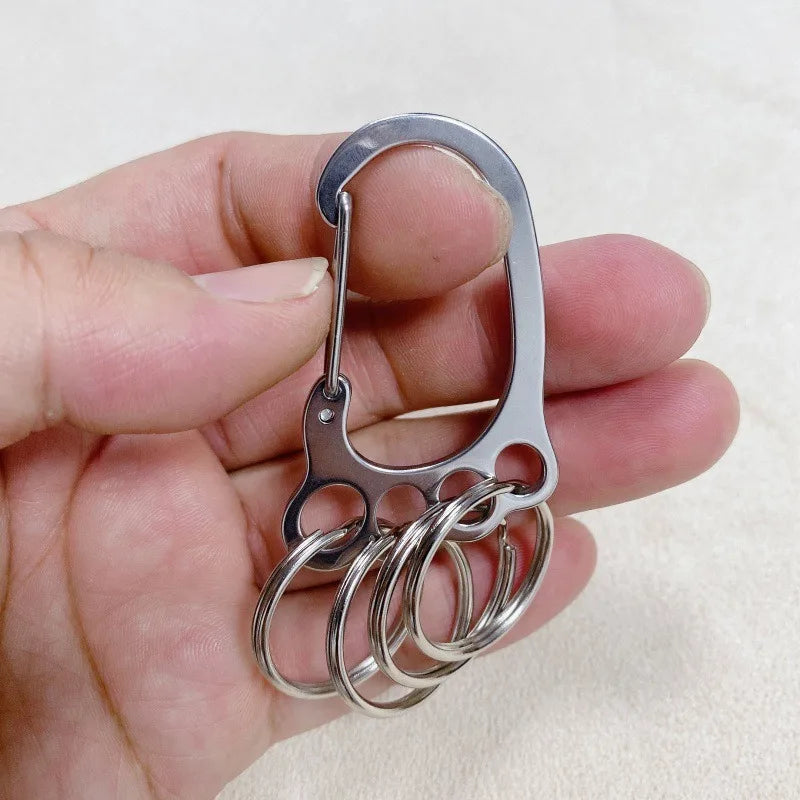 A hand holds a durable stainless steel keychain with multiple interlocking loops.