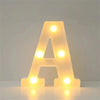 A shaped LED letter light sign glowing yellow on a white surface.