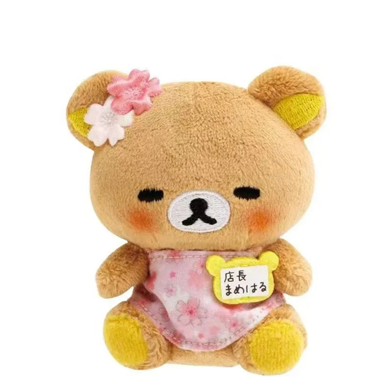 A cute brown bear plush toy with pink flowers on its head and a pink bag pendant.