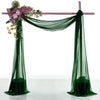 Two panels of sheer green chiffon fabric draped to form a wedding arch backdrop.