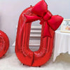 A large red foil number balloon shaped like the number 0, decorated with a matching red bow.