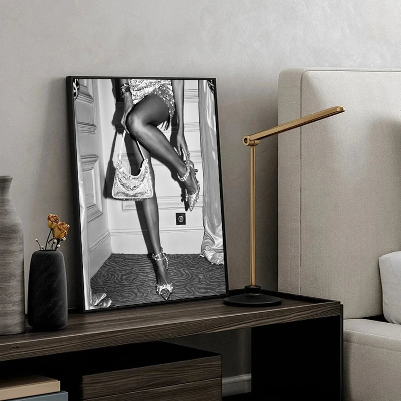 A black and white art print featuring a woman in high heels, displayed on a television screen in a modern living room.