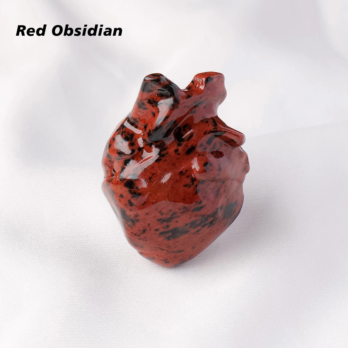 A reddish-brown obsidian heart carving decoration resting on a white background.