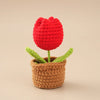 Handcrafted red crochet tulip flower growing in a brown pot