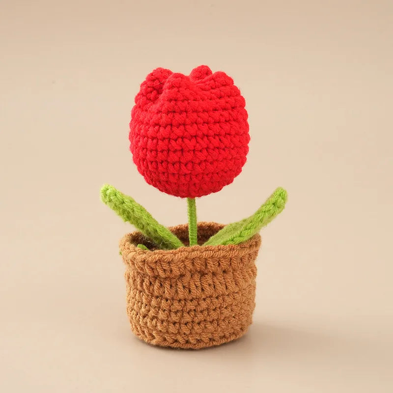 Handcrafted red crochet tulip flower growing in a brown pot