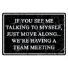A black marble-textured sign with white text that reads If you see me talking to myself, just move along We're having a team 