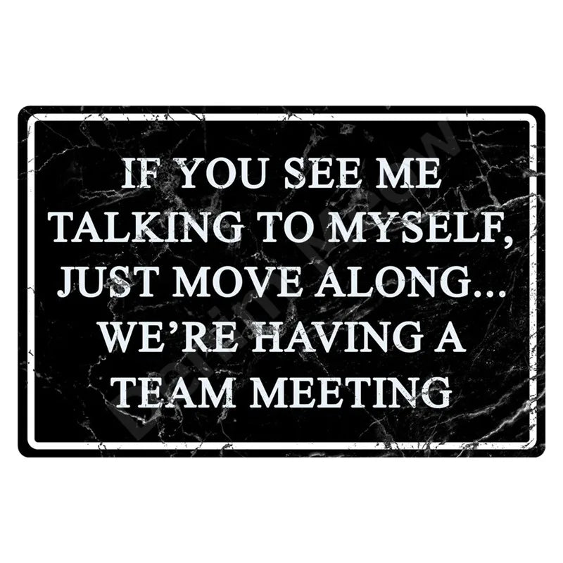 A black marble-textured sign with white text that reads If you see me talking to myself, just move along We're having a team 