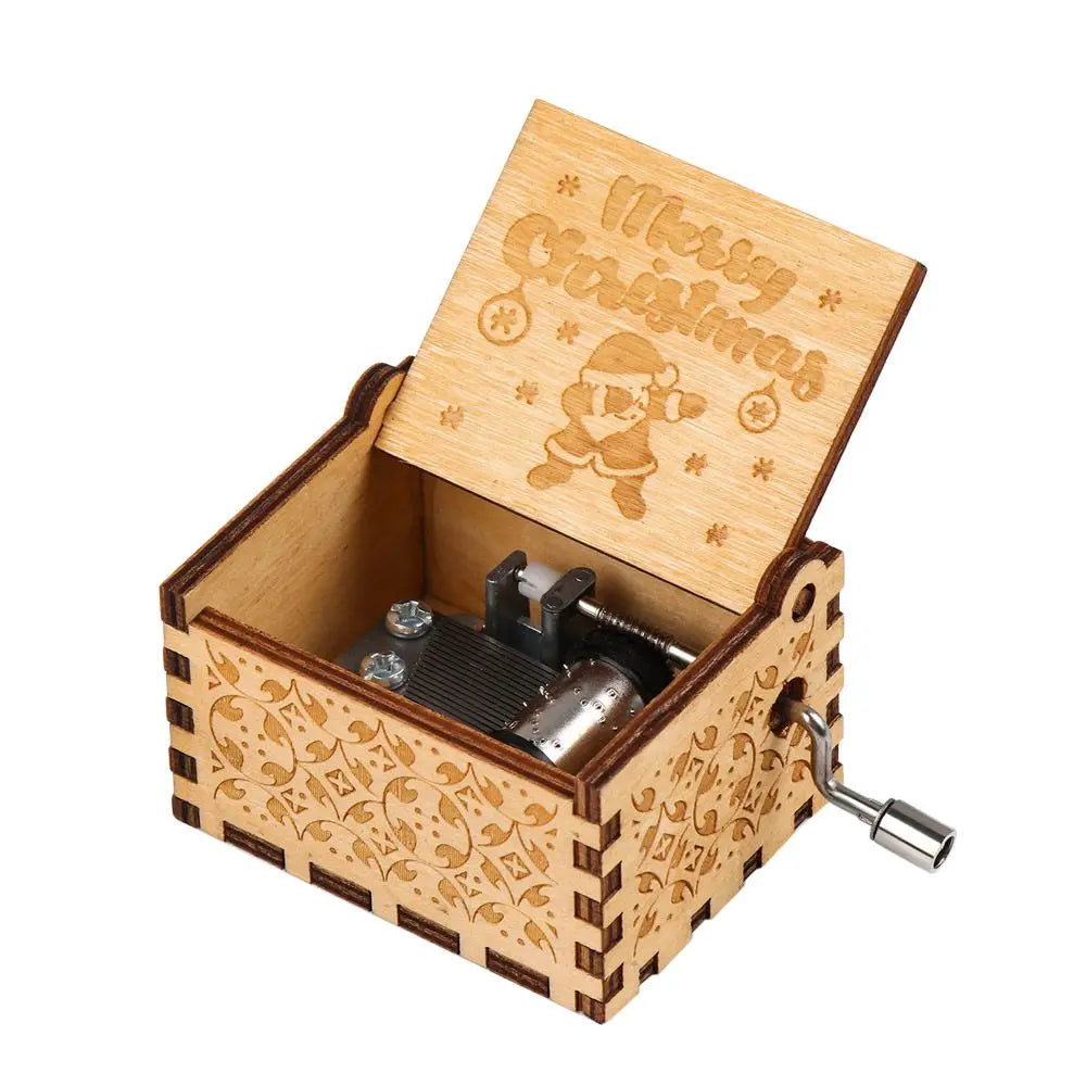 A vintage hand-cranked wooden music box with a lid featuring the text Merry Christmas and an ornate wooden box.