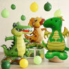 A collection of foil animal balloons featuring green and yellow dinosaurs and other animals.