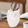 White heart-shaped resin pen organizer with a pair of scissors and a pen inside