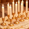 Vintage iron candlestick holders with white candles arranged on a lace cloth for table centerpieces