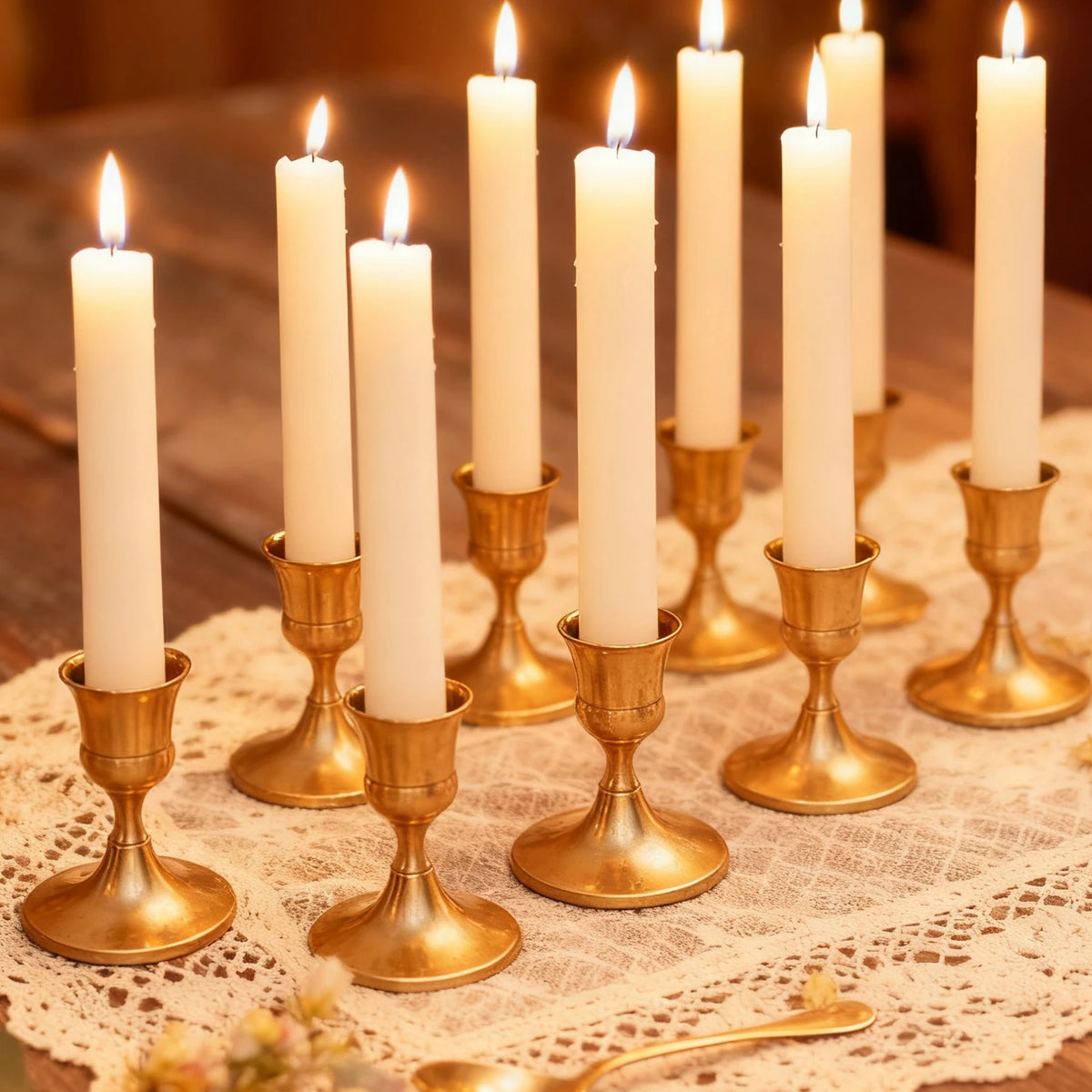 Vintage iron candlestick holders with white candles arranged on a lace cloth for table centerpieces