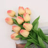 A bouquet of realistic artificial tulips in shades of peach and cream.