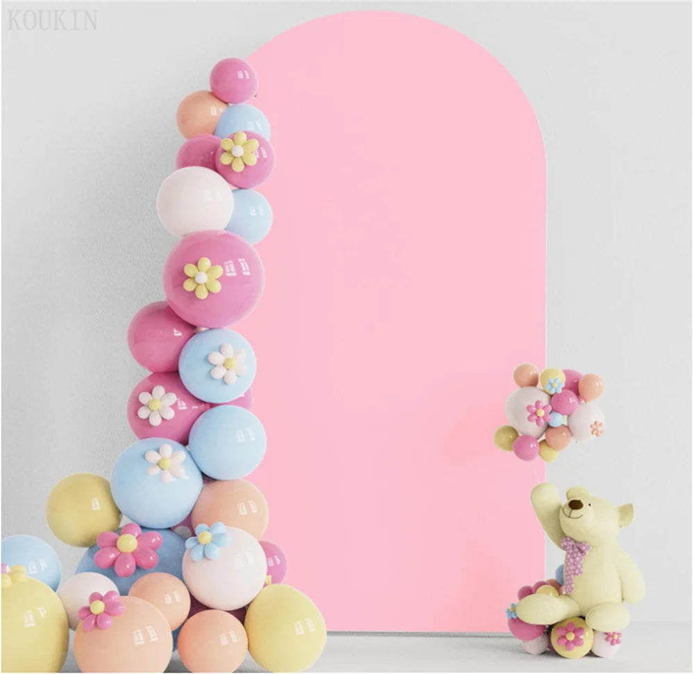 Disposición vertical de globos rosa y azul con acentos florales amarillos sobre un fondo rosa sólido.