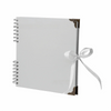 Bloc-notes d'album photo blanc à plat avec un fermoir doré décoratif et un ruban blanc attaché sur la couverture.