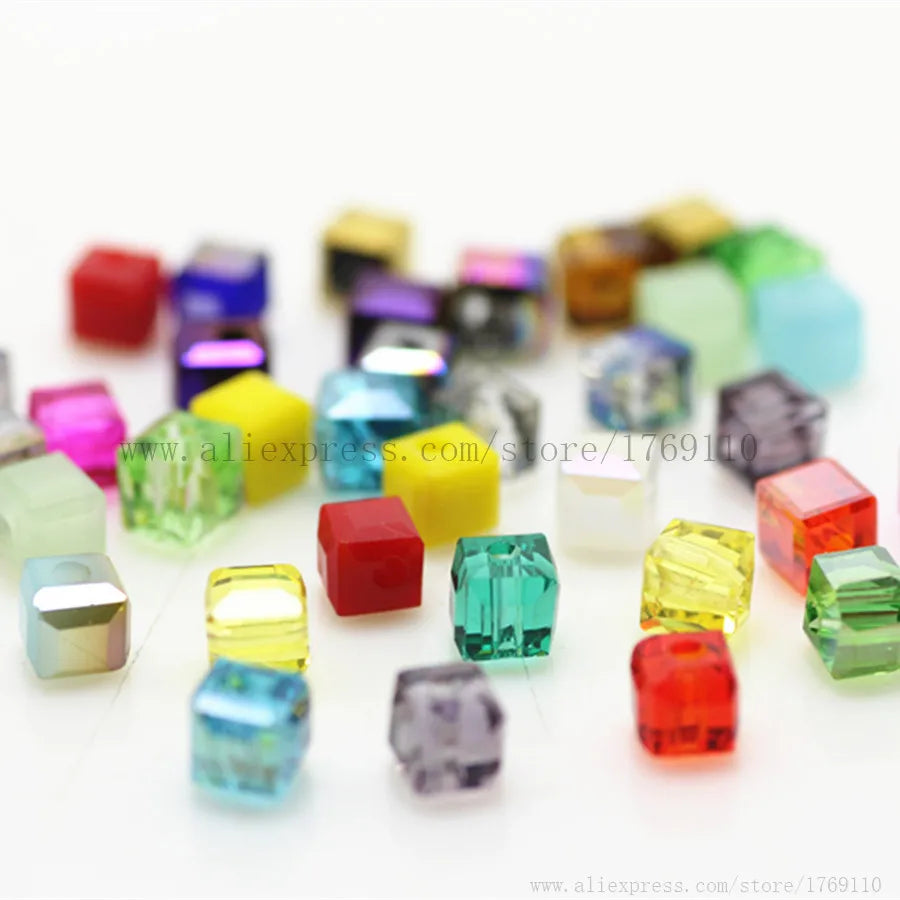 A collection of square cut glass crystal beads in various colors including red, green, yellow, blue, and purple.