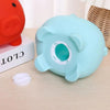 Light blue pig-shaped coin storage bank with a tray next to an orange piggy bank.