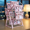 A pink metal rotating Ferris wheel photo frame displaying twelve small framed pictures.