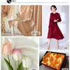 A display of satin fabric in various shades of pink and orange, including floral patterns and solid colors for sewing project