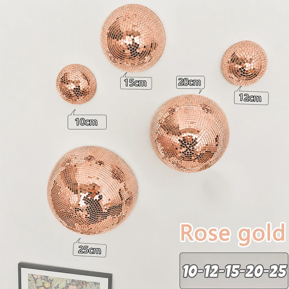 A collection of rose gold disco balls of various sizes mounted on a white background.