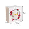A rectangular white acrylic gift box with a floral wreath design on the front.