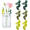 A set of three green human-shaped plant supports for hydroponic growth, including a pink rose stem.