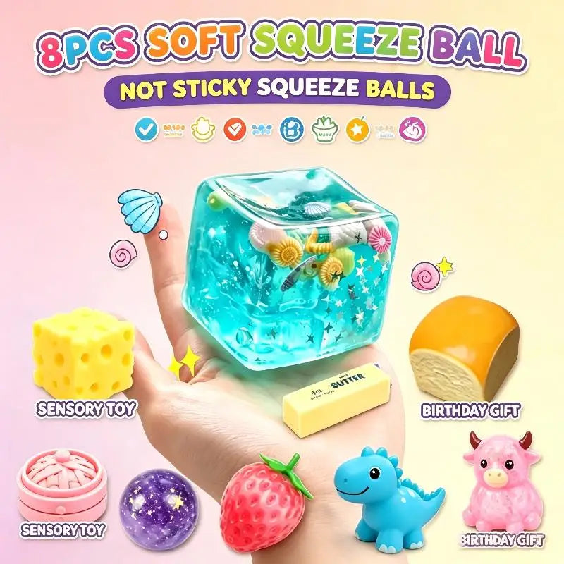 A hand holds an 8-piece set of soft, non-sticky squeeze balls including a large blue cube, a yellow cube, and various small t