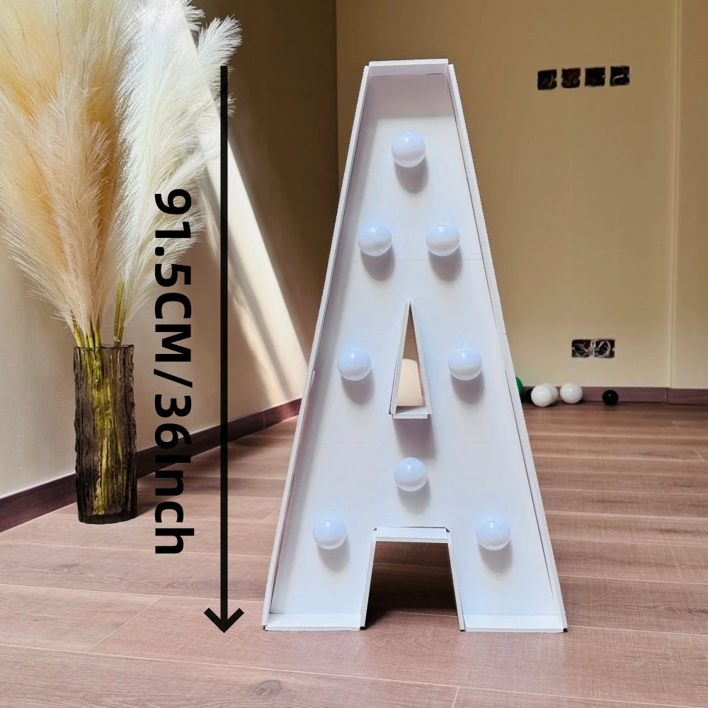 A large white marquee letter shaped like the letter A for party decor displayed on a wooden floor.