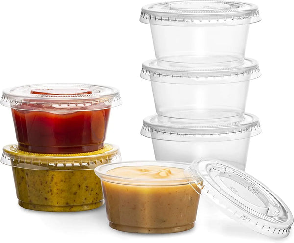 A stack of clear disposable plastic bowls with lids, including a jar of yellowish-green jam or preserve.