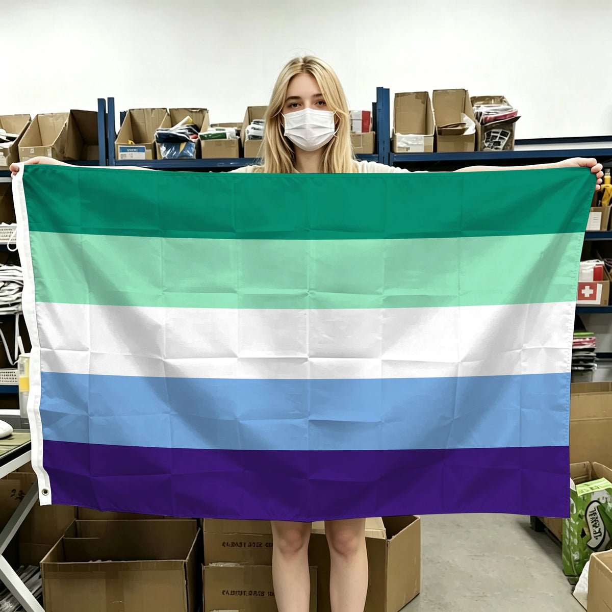 A person holds up a horizontal Pride flag banner with six colored stripes: green, white, light blue, white, blue, and purple.
